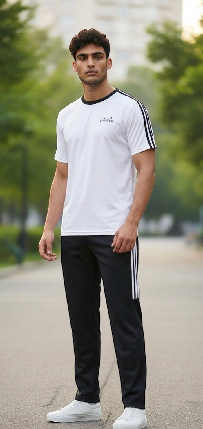 Swift Gear athletic tracksuit set with white t-shirt featuring black piping and black pants with white stripes. Model is wearing the set outdoors.