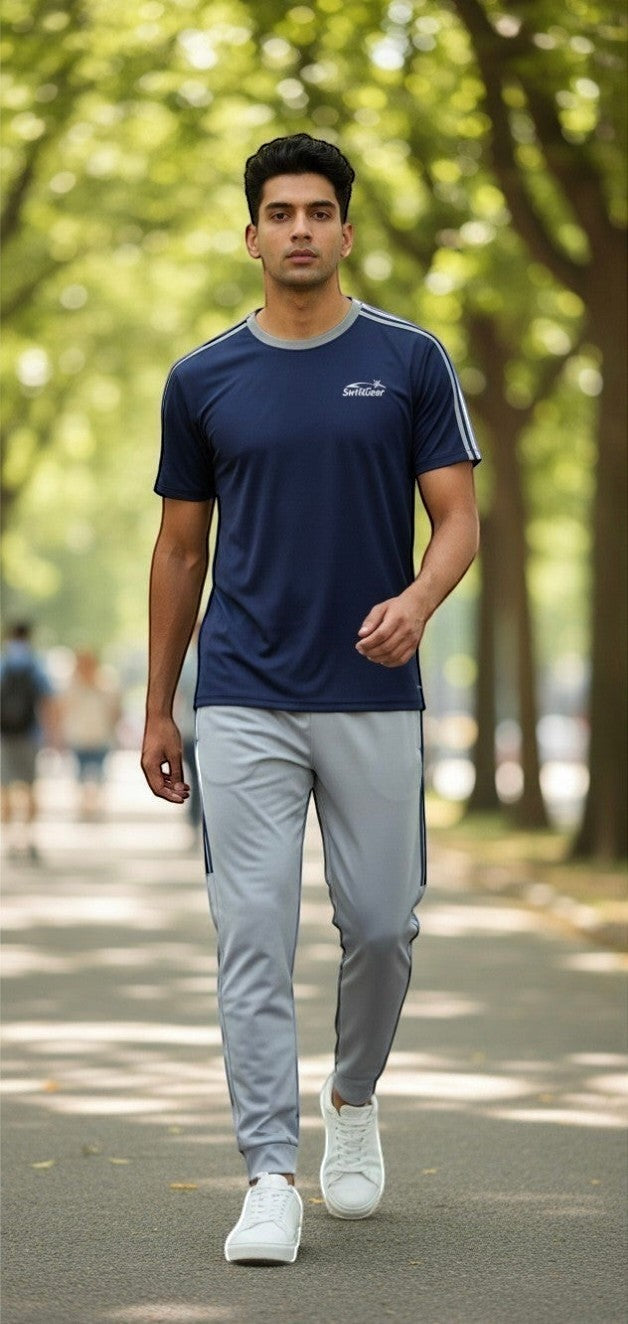 Swift Gear navy blue short-sleeve t-shirt with grey trim and light grey track pants with navy stripes. Model is walking outdoors.