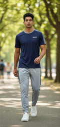 Swift Gear navy blue short-sleeve t-shirt with grey trim and light grey track pants with navy stripes. Model is walking outdoors.